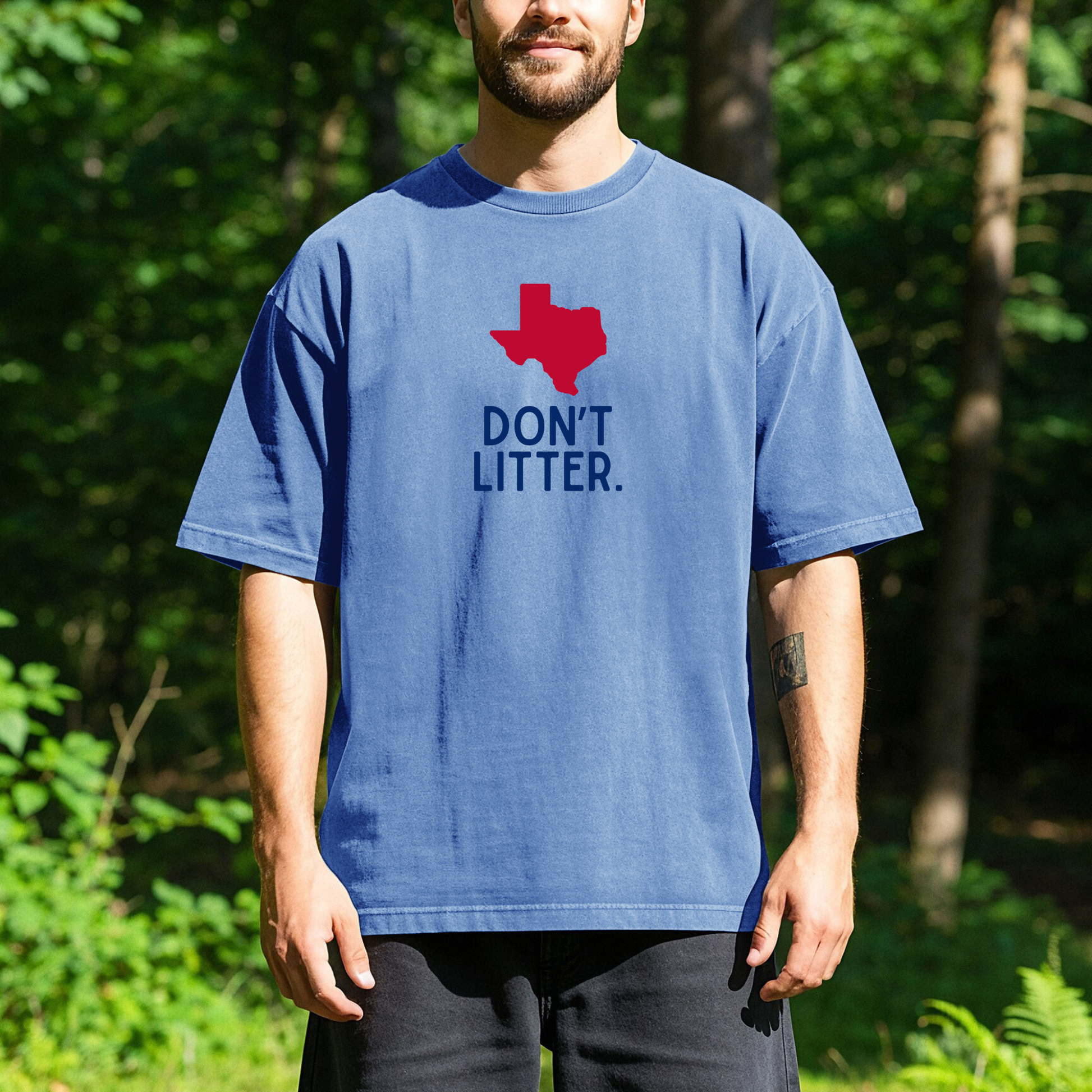 Person standing outdoors wearing a blue t-shirt with a red outline of the state of Texas and the words Don't Litter printed below it.