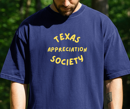 person standing outdoors wearing a navy blue -shirt with yellow text that reads Texas Appreciation Society.
